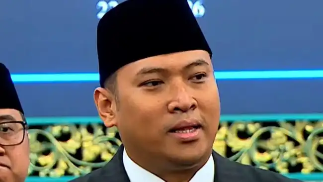 Beritagosip.com - Seorang petugas pemerintah tinggi memutuskan untuk keluar membela program Makan Bergizi Gratis (MBG) dari berbagai kritik yang menyebut bahwa inisiatif nutrisi itu menghabiskan anggaran negara dan menyebabkan perbaikan infrastruktur sekolah tertunda. Kepala Badan Gizi Nasional (BGN) Sudaryono menghadapi tugas yang tidak mudah ketika viralnya sebuah foto menampilkan siswa-siswi dari sekolah dasar SDN Tanggirejo yang terletak di Grobogan, Jawa Tengah, sedang menikmati porsi MBG mereka di depan ruang kelas dengan atap yang dalam kondisi sangat rusak dan mengkhawatirkan. Dengan data dan fakta di tangannya, Sudaryono melakukan klarifikasi publik yang tegas. Pemerintah, demikian pengakuannya, sebenarnya terus-menerus meningkatkan skala program revitalisasi infrastruktur sekolah bahkan ketika program MBG sedang berjalan penuh. Bukti konkret itu dapat dilihat dari pencapaian pemerintah pada tahun 2025 lalu. Pemerintah telah berhasil merenovasi dan memperbaiki lebih dari 16.000 unit sekolah di seluruh nusantara. Angka yang lebih impresif lagi terungkap untuk target tahun ini, di mana pemerintah menargetkan perbaikan pada lebih dari 70.000 satuan sekolah, dengan beberapa pejabat senior bahkan mengindikasikan bahwa target itu bisa melonjak hingga mendekati angka 90.000 sekolah. "Tahun ini yang mau direnovasi itu lebih dari 70 ribu, bahkan Pak Mendikdasmen pernah mengutarakan bisa jadi hampir 90 ribu sekolah. Yang itu langsung dari pemerintah pusat," ungkap Sudaryono saat ditemui di kantor kerjanya pada Rabu (29/7). Narasi yang terus berkembang di masyarakat bahwa dana negara seluruhnya terkuras habis karena MBG, kata Sudaryono, tidak selaras dengan situasi lapangan yang sebenarnya. Justru, berbagai inisiatif strategis pemerintah terus berjalan bersamaan tanpa terjadi pengurangan signifikan. "Kan ada semacam anggapan bahwa anggaran negara ini habis karena MBG. Pada kenyataannya ada MBG, yang dulu pupuk tidak cukup, sekarang pupuknya cukup. Bahkan harganya didiskon 20 persen," imbuhnya, menunjukkan bahwa program subsidi pertanian juga malah mengalami peningkatan, bukan penurunan. Sudaryono melanjutkan dengan menunjukkan contoh lain dari program-program lain yang juga tetap mengalami peningkatan pembiayaan. Program revitalisasi sistem irigasi pertanian, misalnya, mendapat porsi anggaran yang juga terus bertambah. Pada tahun yang lalu, alokasi untuk irigasi mencapai Rp12 triliun, kemudian naik menjadi Rp14 triliun pada tahun sekarang, dan diproyeksikan akan terus meningkat pada tahun-tahun mendatang. Dalam penjelasannya lebih lanjut, Sudaryono menjauhkan dugaan bahwa keadaan sekolah-sekolah rusak merupakan hasil langsung dari kehadiran program MBG. Kerusakan infrastruktur sekolah sudah ada jauh sebelum MBG diluncurkan sebagai kebijakan publik. "Dulu enggak ada MBG, sekolah itu rusak memang sebelum ada program MBG. Ini sekarang oleh Presiden (Prabowo Subianto) diperbaiki," katanya dengan nada yang menekankan tanggung jawab historis. Untuk menyikapi masalah sekolah yang masih dalam kondisi rusak, Sudaryono mengundang masyarakat luas untuk secara aktif melaporkan setiap satuan pendidikan yang mereka temukan dalam kondisi tidak layak. Pemerintah telah menyediakan saluran pengaduan resmi melalui Kementerian Pendidikan Dasar dan Menengah untuk memudahkan proses pelaporan. "Kalau ada sekolah rusak yang ditemukan itu cukup lapor. Ada portalnya di Dikdasmen, pasti diperbaiki," jelasnya dengan keyakinan bahwa sistem yang ada sudah responsif terhadap keluhan publik. Terakhir, Sudaryono mendesak masyarakat agar tidak lagi membandingkan atau membandel-bandingkan program MBG dengan kondisi infrastruktur sekolah. Kedua inisiatif itu, jelasnya, merupakan program yang terpisah sama sekali dengan mekanisme pembiayaan yang juga berbeda satu sama lain. "Dapur MBG ini yang bangun adalah mitra, sementara perbaikan sekolah ini dua hal yang berbeda," pungkasnya, menekankan perbedaan fundamental dalam struktur dan implementasi kedua program tersebut.