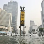 Aktivis Greenpeace Bundaran HI membentangkan spanduk protes krisis iklim di Patung Selamat Datang
