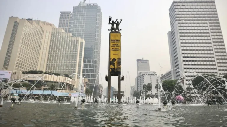 Aktivis Greenpeace Bundaran HI membentangkan spanduk protes krisis iklim di Patung Selamat Datang